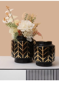 Dettaglio di vasi in ceramica nera con motivi geometrici a V in oro metallizzato