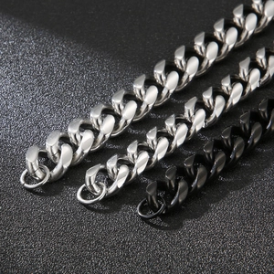 Macro detail of polished stainless steel Cuban link chains in silver and black finishes