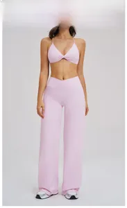 Detail of pink yoga set with cross-waist flare pants and knotted sports bra