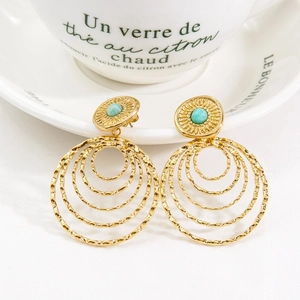 Detail of bohemian gold layered circle earrings with sky blue natural stone inlay