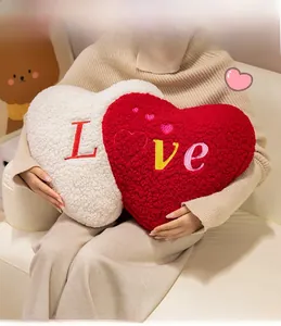 Detail of red and white plush heart pillows with Love embroidery and soft sheepskin texture