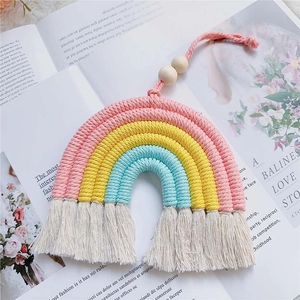 Detail of a handmade rainbow tassel wall hanging with colorful cotton ropes and wood beads