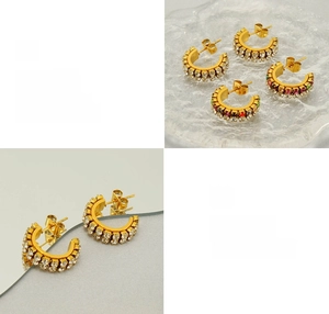 Détail de boucles d'oreilles en C plaquées or 18K avec zircons colorés brillants