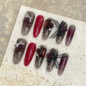 Handmade stiletto press-on nails with red lace bows, polka dots, and rose 3D art