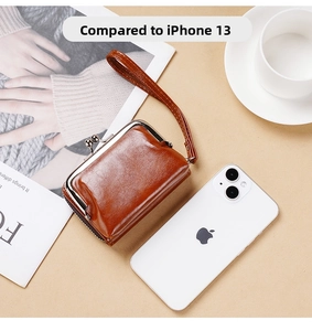Portamonete vintage in pelle marrone accanto a iPhone 13 per confronto dimensioni