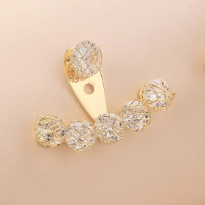 Detail of gold ear jacket earrings featuring crystals wrapped in fine metallic mesh wire