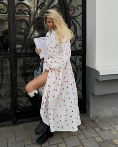 Détail d'une robe maxi blanche en coton avec manches lanternes et motifs de cœurs rouges