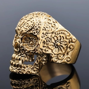 Macro shot of gold stainless steel skull ring with vintage floral carvings and polished finish