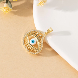 Detail of gold teardrop evil eye pendant featuring blue pupil and clear zircon pavé border