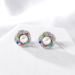 Orecchini a spirale in argento con perla bianca e sei strass colorati su sfondo di seta