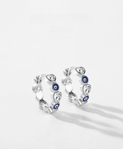 Detailed macro view of S925 silver hoop earrings with blue enamel evil eye and heart zirconia