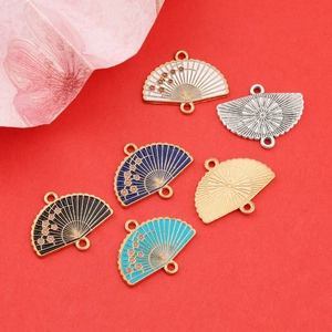 Detailed macro of fan-shaped alloy pendants with plum blossom enamel for DIY jewelry making