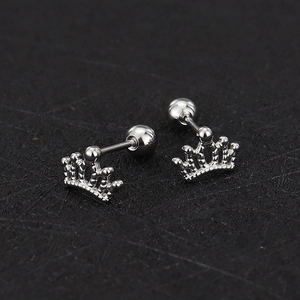Macro shot of silver crown cartilage studs with screw ball back in polished titanium steel