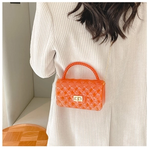 Detail of small orange translucent jelly bag with pearl handle and gold chain strap