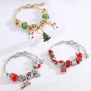 Christmas DIY beaded charm bracelets with enamel holiday pendants on white steps