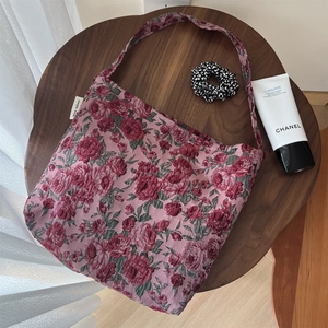 Sac fourre-tout élégant vintage en jacquard floral rose avec bandoulière sur table