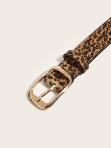 Détail de la ceinture à motif léopard avec boucle en métal doré sur fond neutre et élégant