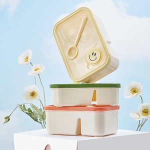 Stack of colorful bento lunch boxes with cutlery compartment and smiley face design