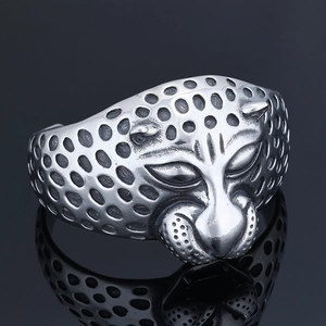 Detailed view of silver leopard head bracelet with textured metal finish on black background