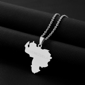 Macro shot of silver stainless steel Venezuela map pendant with engraved text detail