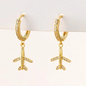 Golden airplane stud earrings with micro-pave zircons on white cardboard background
