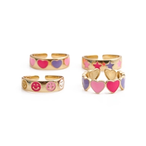 Detail view of four gold-plated enamel rings with heart, star, and smiley face motifs