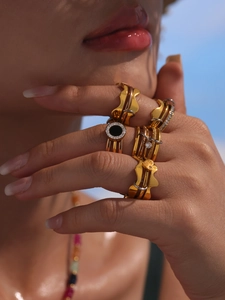 Gros plan de bagues géométriques superposées plaquées or 18 carats avec motifs à vagues