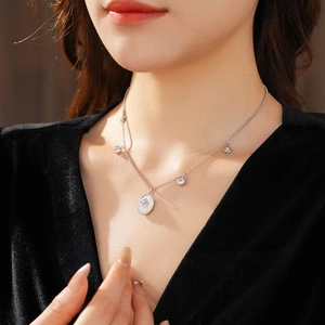 Dettaglio della collana in argento con ciondolo a stella e ovale sul collo di una modella