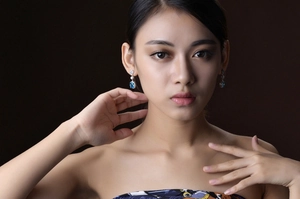 Elegant rectangular blue gemstone drop earrings on model with silver hook setting
