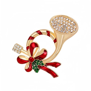 Close-up of a Christmas horn brooch with red enamel bow and clear crystal accents