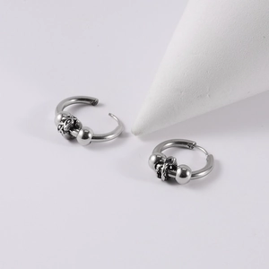 Close-up of gothic stainless steel hoop earrings featuring embossed cross flower detail