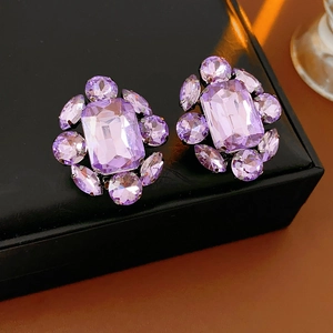 Vue macro détaillée de boucles d'oreilles vintage avec cristaux violets et strass géométriques