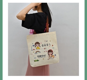 Asian model wearing a minimalist cream canvas tote bag with brown straps and cartoon print