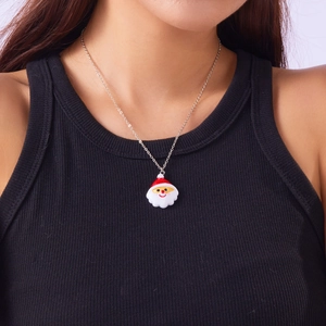 Nahaufnahme eines Weihnachtsmann-Harzanhängers an einer Silberkette am Model