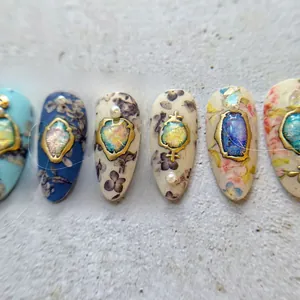 Macro view of vintage style press-on nails with 5D gold frames, gems, and pearls