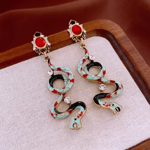 Vintage gold snake earrings with colorful enamel, red gemstone and sparkling rhinestones