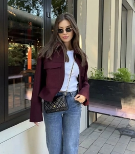 Détail d'un manteau en laine rouge bordeaux vintage avec poches poitrine et col à revers