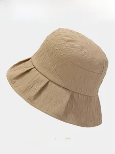 Close-up of khaki bucket hat featuring unique crinkle texture and wide brim detail