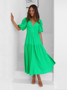 Detailed view of puff sleeves and deep V-neckline on bright green tiered vacation dress