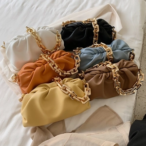 Cloud clutch bags with thick gold chains shown in six diverse colors on white fabric