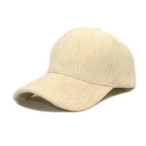 Detail of off-white baseball cap featuring 3D embossed M letter texture and knit fabric
