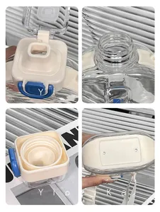 Detail view of square plastic water bottle showing straw lid, blue lock, and nylon strap