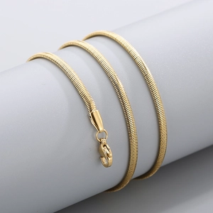 Detailed view of the gold snake chain necklace with a lobster clasp on a display stand
