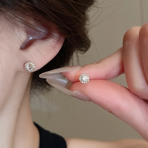 Macro detail of silver sterling halo stud earrings with sparkling cubic zirconia stones