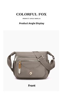 Front detail of grey nylon crossbody bag with multiple zippered pockets and wide logo strap