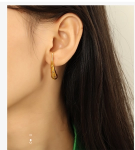 Close-up of 18K gold plated teardrop earring with multi-color stones on a model