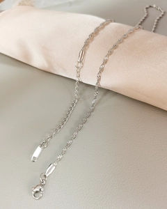 Macro shot of silver water wave chain necklace with teardrop tail and lobster clasp