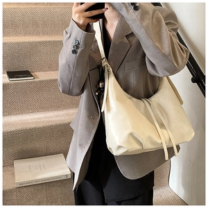 Detail of off-white soft PU leather tote bag with adjustable strap and drawstring closure