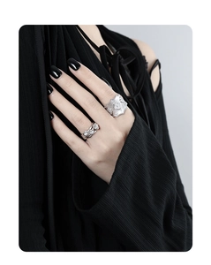 Macro detail of silver layered ring with rose motif and zircon inlay on finger