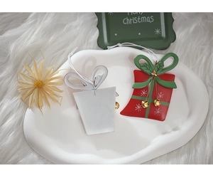 Close-up of red and white iron gift box ornaments with golden bells and snowflake patterns